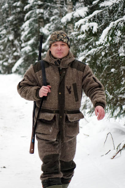 istock Hunter with gun and hunting ammunition is a winter forest. 1187172421