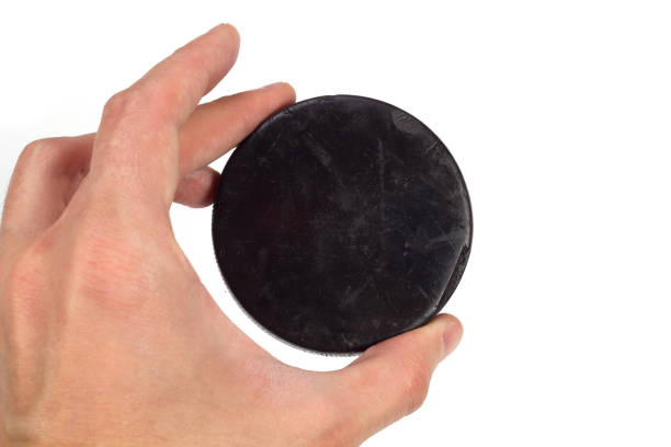 istock Old hockey puck in hand on white background 1187173568
