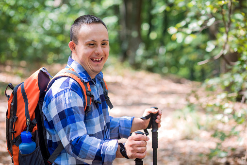 Teenager with Down syndrome hiking in forest