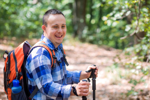 In love with nature Teenager with Down syndrome hiking in forest disabled person hiking outdoors stock pictures, royalty-free photos & images