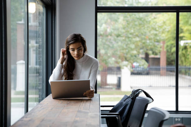 istock Pulling back her hair, woman reads on her digital tablet 1187176006