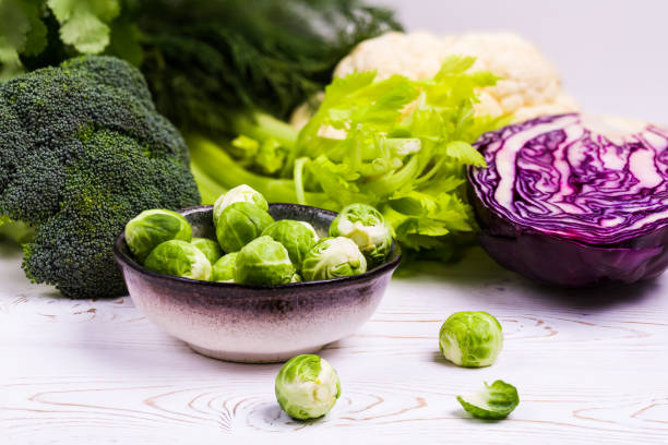 istock Close-up of assorted fresh vegetables on a black slate on a wooden table: cabbage, broccoli, cauliflower and Brussels sprouts and red cabbage-organic products 1187176648