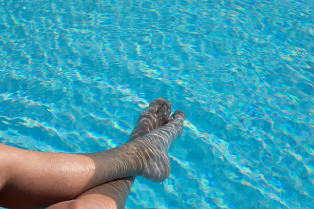 Someone relaxing the feet in the pool
