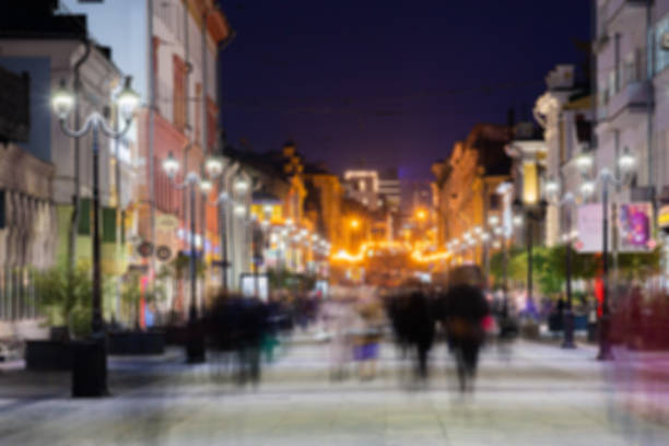 istock Defocused image, bokeh effect. Evening or night cityscape. Long exposure. People walk on a pedestrian street. Nizhny Novgorod, Russia 1187179334