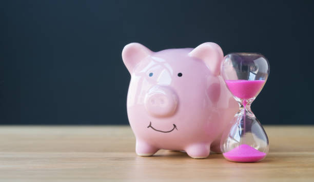 skarbonka z klepsydrą na różowo - retirement pension hourglass concepts zdjęcia i obrazy z banku zdjęć