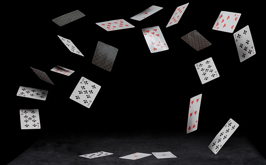 playing cards fall on black table on a dark background