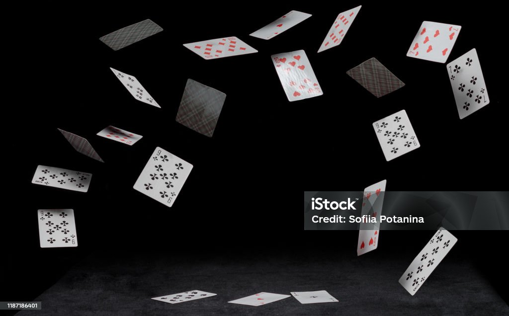playing cards fall on a black table playing cards fall on black table on a dark background Playing Card Stock Photo