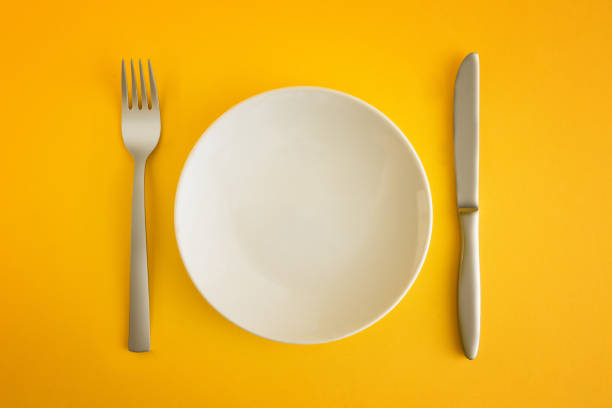 empty platter on yellow background - fork silverware table knife silver imagens e fotografias de stock