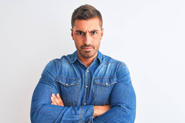 istock Young handsome man wearing denim jacket standing over isolated background skeptic and nervous, disapproving expression on face with crossed arms. Negative person. 1187189069