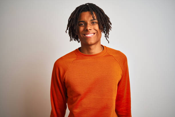 istock Afro american man with dreadlocks wearing orange sweater over isolated white background with a happy and cool smile on face. Lucky person. 1187194075