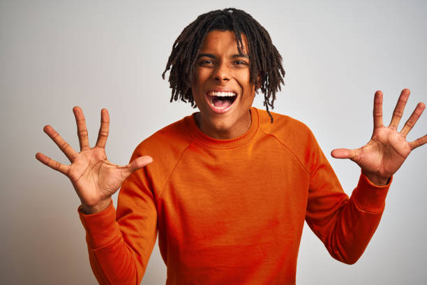 istock Afro american man with dreadlocks wearing orange sweater over isolated white background celebrating crazy and amazed for success with arms raised and open eyes screaming excited. Winner concept 1187194112