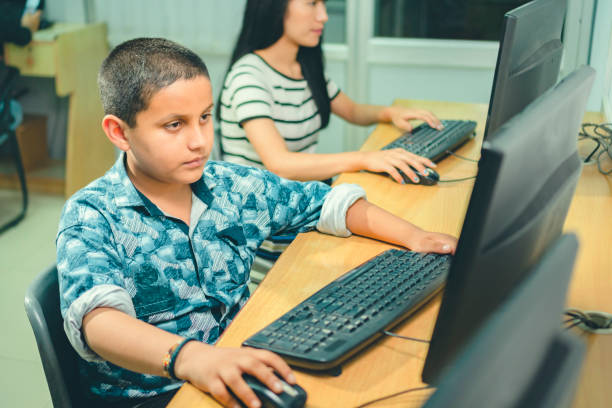 adolescente niño da un examen en línea a través de internet. - computer lab child internet development fotografías e imágenes de stock