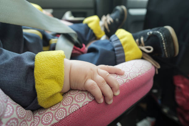 bambino che dorme in seggiolino auto. nessuna faccia - vehicle interior indoors window chair foto e immagini stock