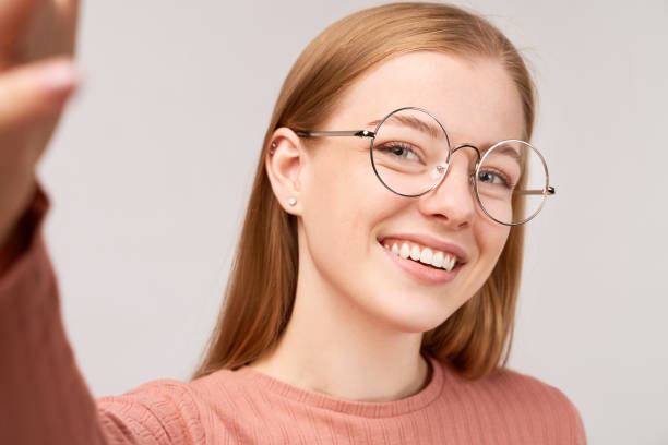 hermosa chica con pelo de jengibre aislado en la pared - vertical caucasian glasses red hair fotografías e imágenes de stock