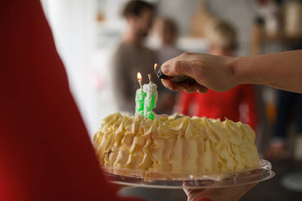 istock Igniting candles on a birthday cake 1187201774