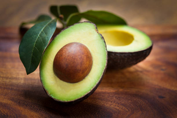 istock Avocado halves on wooden board with leaves 1187201828