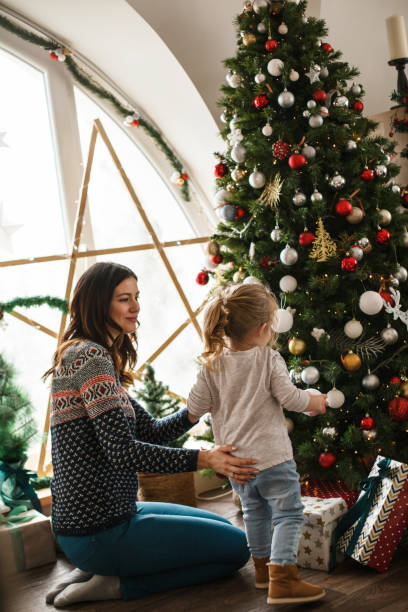 istock Little girl decorating Christmas tree with her mother 1187202097