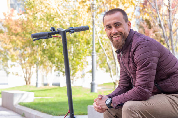 istock Young man laughing and resting next to the scooter 1187208254