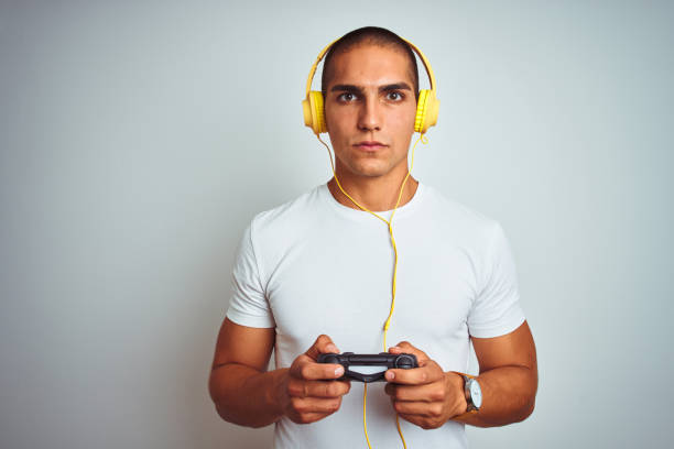 istock Young handsome man playing videogames using headphones over white isolated background with a confident expression on smart face thinking serious 1187208428