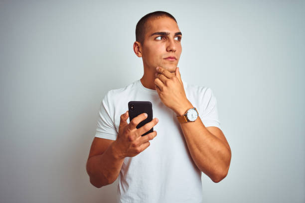 istock Young handsome man using smartphone over yellow isolated background serious face thinking about question, very confused idea 1187208663