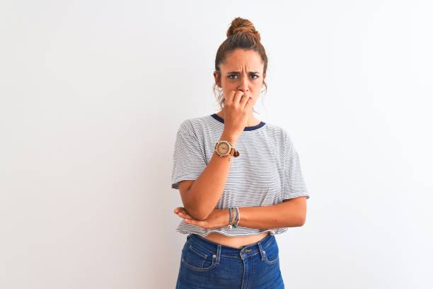 istock Young redhead modern woman wearing a bun over isolated background looking stressed and nervous with hands on mouth biting nails. Anxiety problem. 1187209249