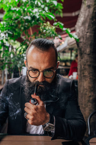 istock Fashionable bearded man smoking pipe 1187210470