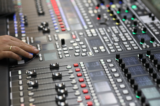 Closeup view of the broadcast audio mixing console. Selective focus.
