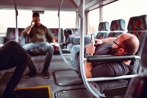 Males Relaxing In The Back Of A Bus