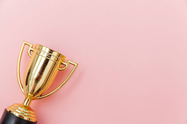 Winner or champion gold trophy cup isolated on pink pastel colorful background Simply flat lay design winner or champion gold trophy cup isolated on pink pastel colorful background. Victory first place of competition. Winning or success concept. Top view copy space armed forces rank photos stock pictures, royalty-free photos & images