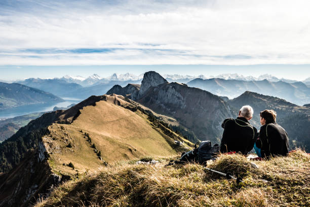 ein paar geniesst die aussicht auf das stockhorn, niesen, eiger, mönch und jungfrau, berner oberland, schweiz - meadow autumn hiking mountain stock-fotos und bilder