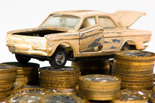 The cost of maintaining an old car A model of an old car is standing on coins. The concept of expensive maintenance of an old car or its disposal cash for cars stock pictures, royalty-free photos & images