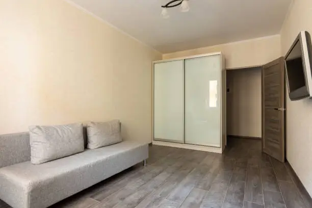 Interior of a small hotel room, TV, wardrobe and sofa