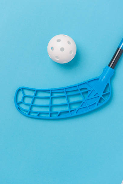 floorball stick and white ball isolated on blue background - teamsport imagens e fotografias de stock