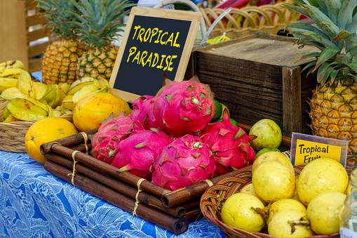 Tropical fruit display of guava, star fruit, pineapple, and dragon fruit at a farmers market