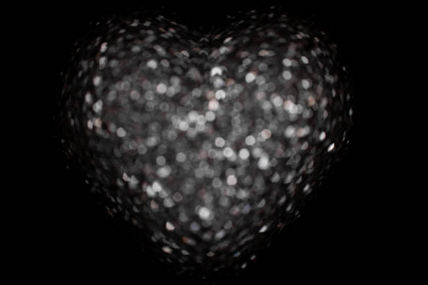 Monochrome abstract background with bokeh defocused lights. Heart shape.
