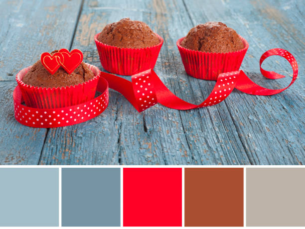 Color matching palette from closeup image or wintertime tasty sweets. Chocolate muffins decorated with cake top in shape of hearts and vibrant red ribbon Color matching palette from closeup image or wintertime tasty sweets. Chocolate muffins decorated with cake top in shape of hearts and vibrant red polka dot ribbon food sample cups stock pictures, royalty-free photos & images