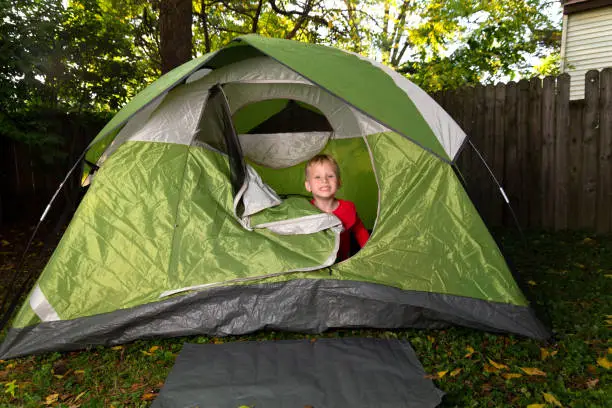 1 Little Boy Plays Alone in His Backyard Inside of a Green Camping Tent