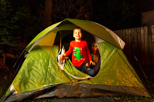 2 Little Boys Play Together With Their Moms in their Backyard in a Green Camping Tent At Night