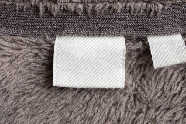 istock Blank white laundry care clothing label on fur texture background 1187245337
