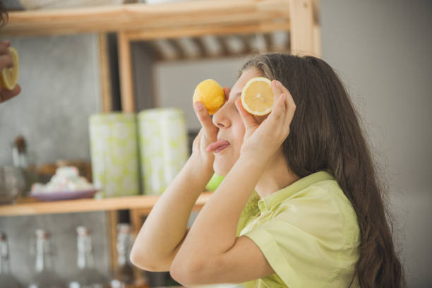 istock Teenage girl making funny faces using lemons 1187245453