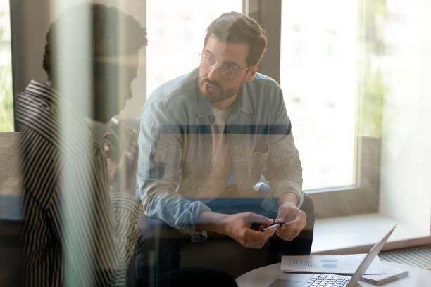 istock Diverse colleagues discussing project statistics behind glass wall 1187245838