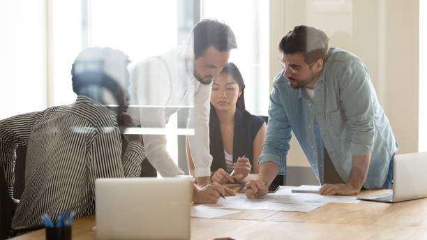 istock Focused diverse employees discussing project statistics at meeting 1187245856