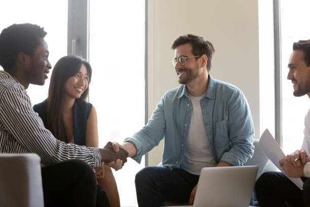 istock Smiling diverse business partners handshaking at group negotiations 1187245861