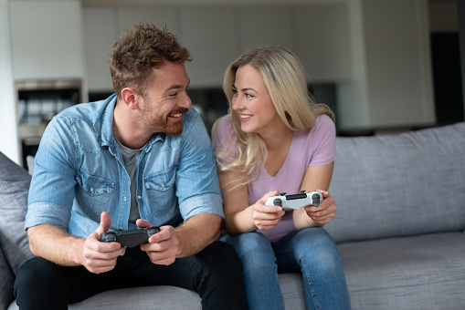Portrait of a loving couple playing video games together at home - lifestyle concepts