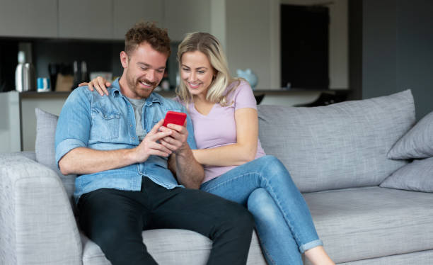 istock Couple social networking at home on a cell phone 1187250872