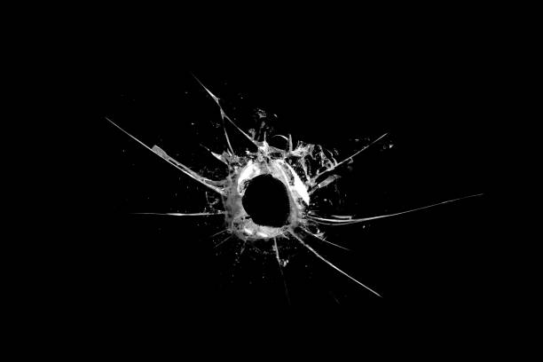 istock hole in the glass with cracks isolated on a black background 1187251802