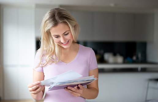 Portrait of a happy woman at home checking the mail and smiling â lifestyle concepts