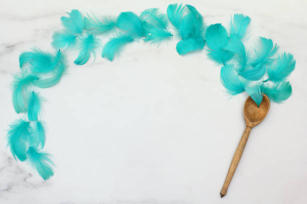 istock Composition of turquoise feathers and a wooden spoon on a marble surface. Flat lay, top view 1187252819
