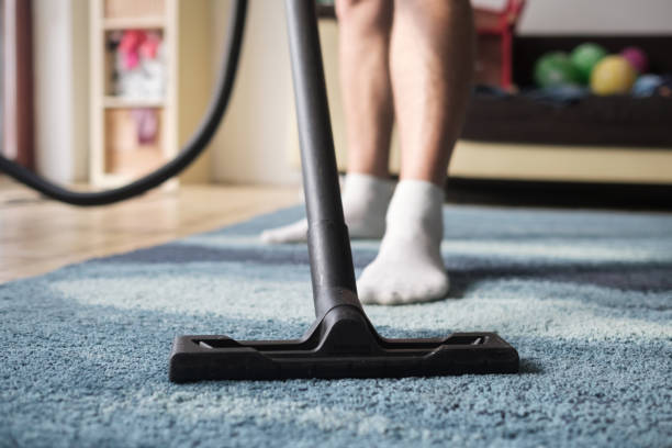 istock Man cleaning from dust a carpet. No face 1187256262