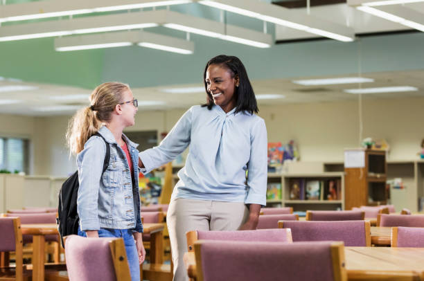 istock Girl with teacher or librarian in elementary school 1187260279